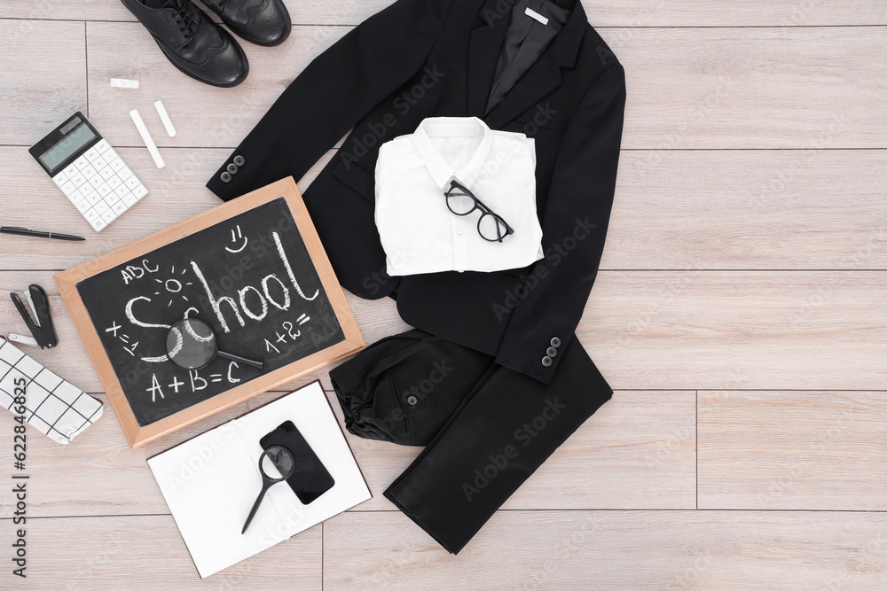 Composition with stylish school uniform, eyeglasses, chalkboard, mobile phone and stationery on wood