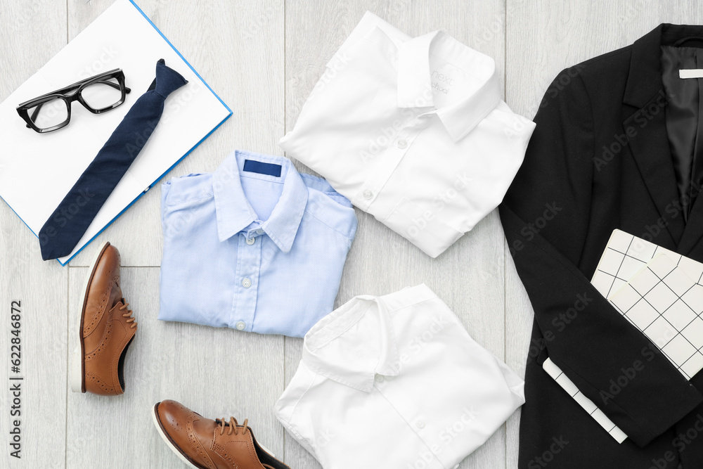 Composition with stylish school uniform, shoes, eyeglasses and tie on wooden background