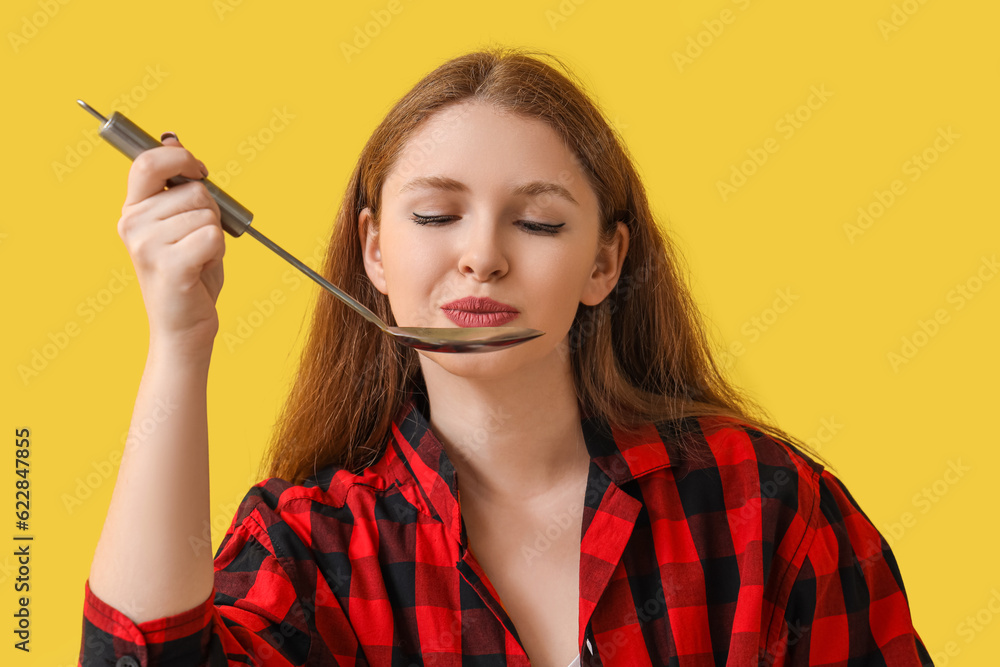 Young woman with ladle on yellow background, closeup