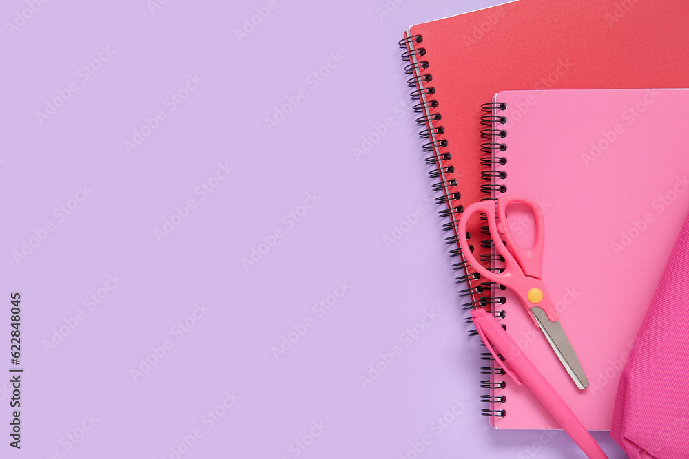 Notebook with pencil case and different stationery on lilac background