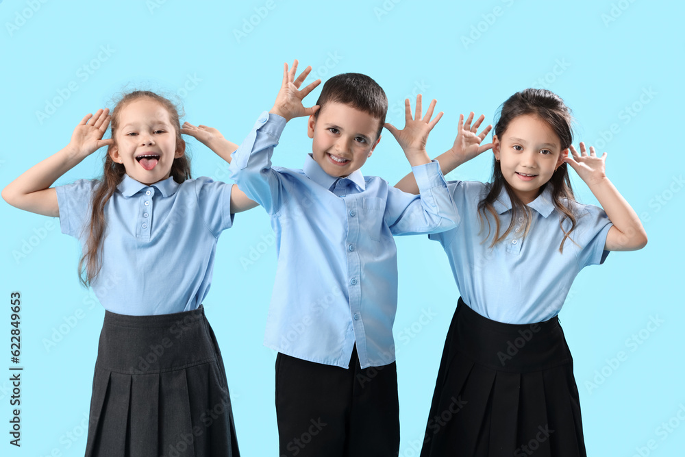 Funny little schoolchildren on light blue background