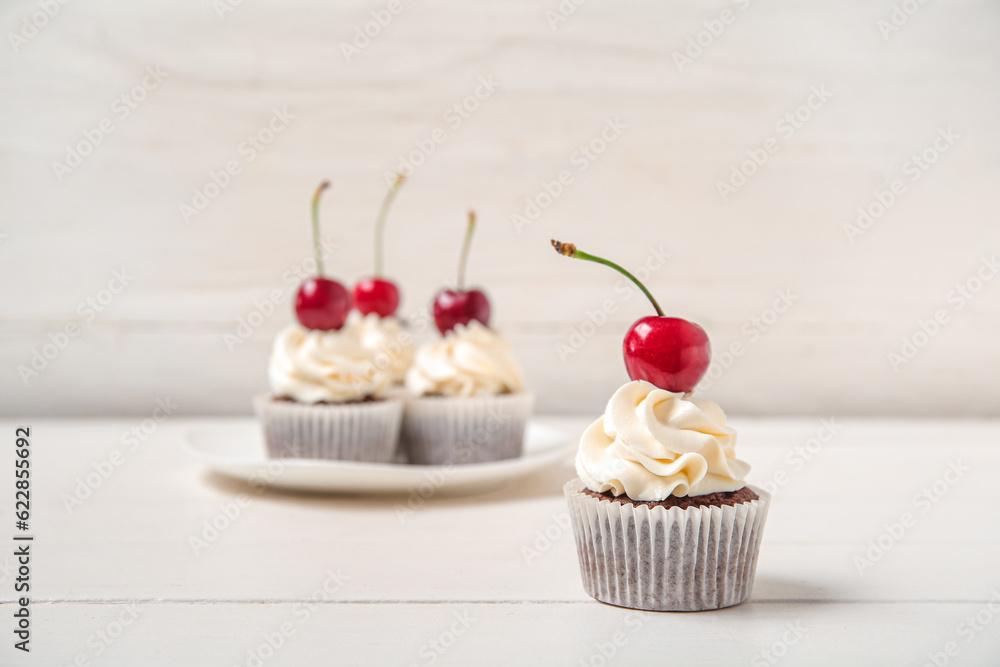 Tasty cherry cupcake on table