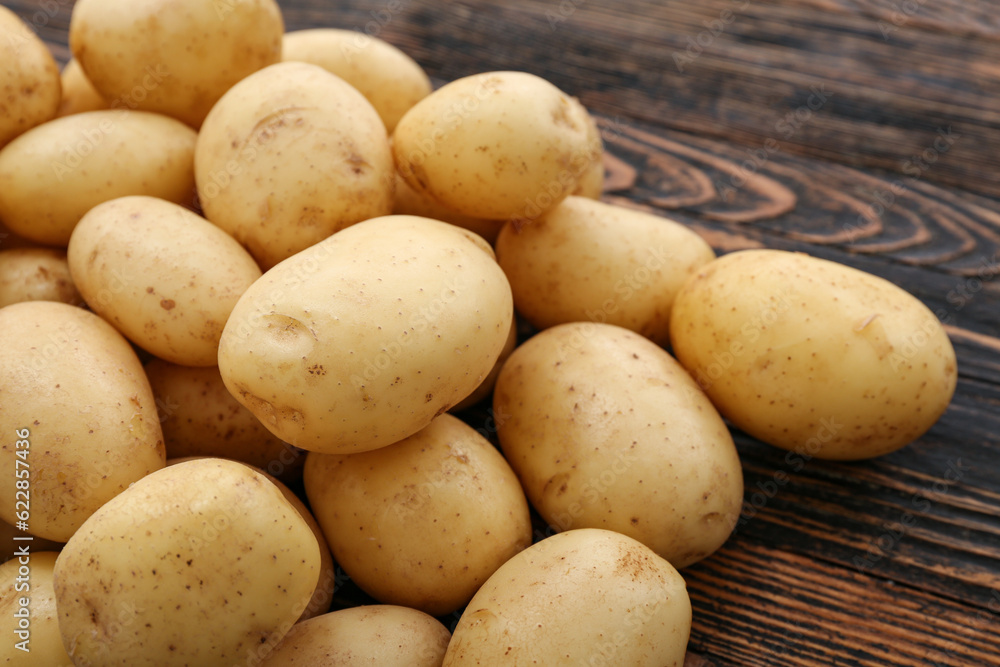 Many raw potatoes on wooden background