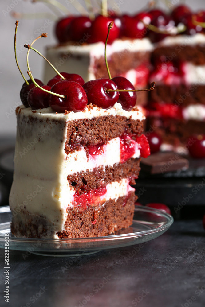 Plate with piece of tasty cherry cake on black table