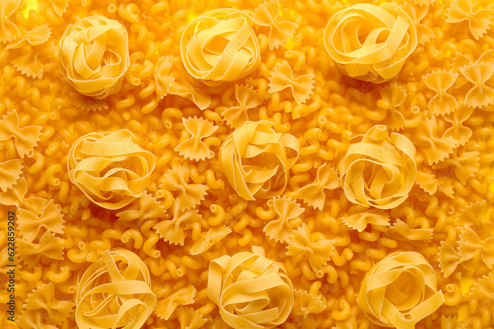 Raw fettuccine, farfale and cavatappi pasta as background, closeup