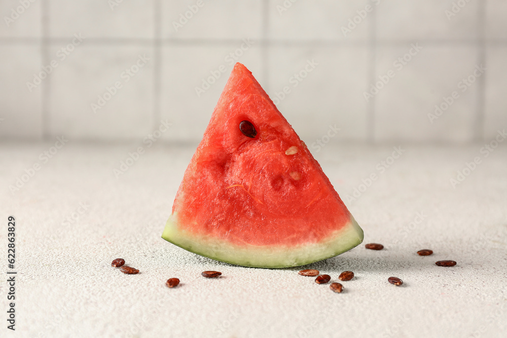 Piece of fresh watermelon and seeds on white table