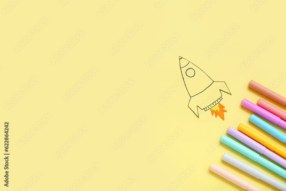 Drawn rocket and markers on yellow background