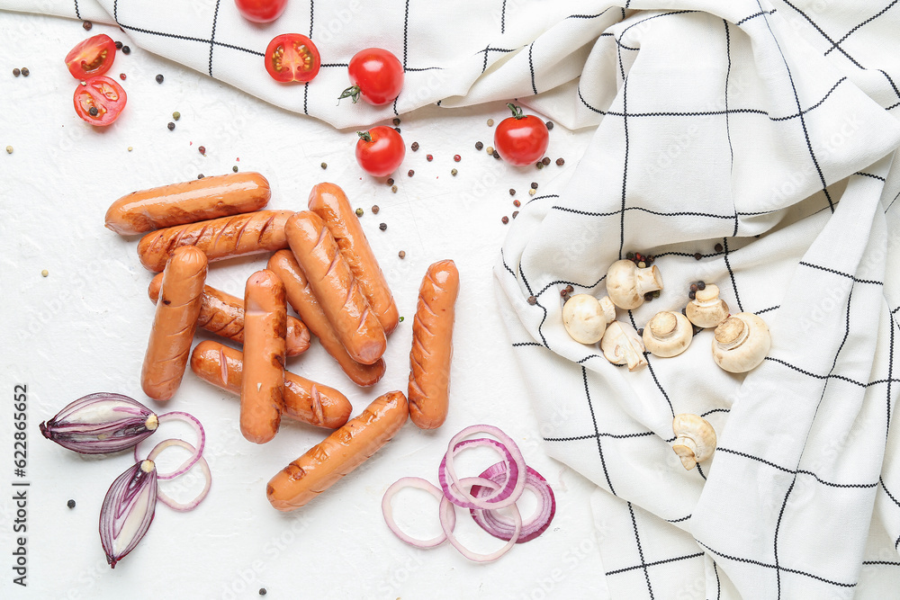 Grilled sausages with mushrooms and vegetables on white table