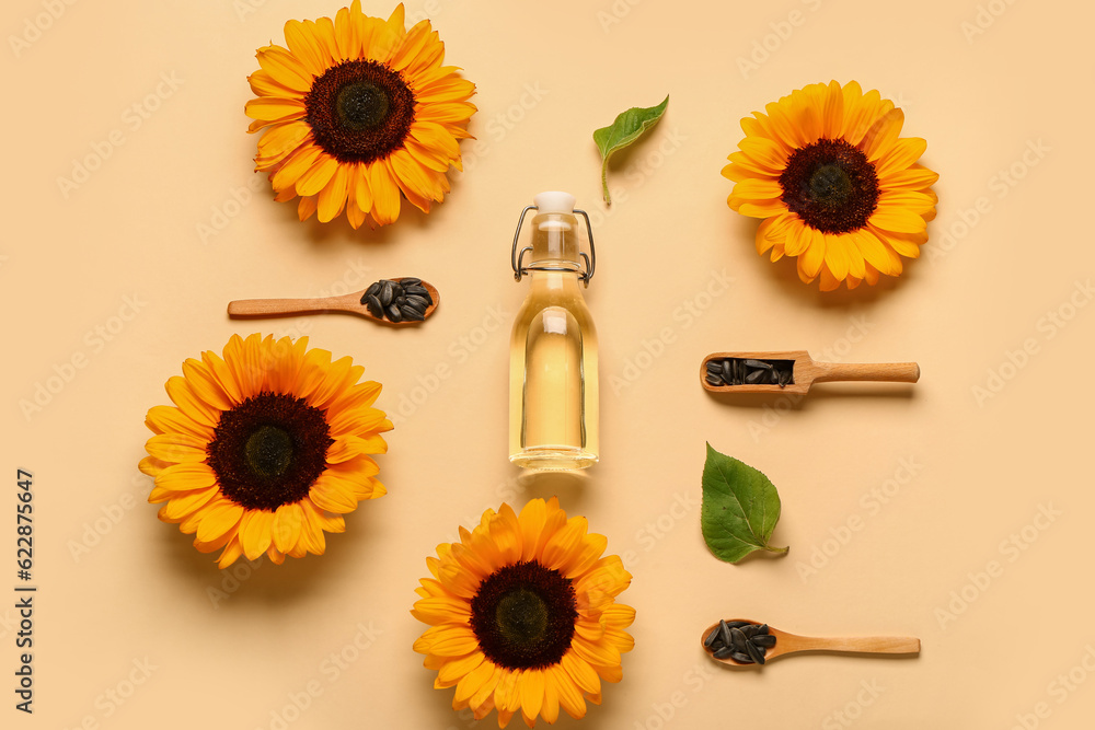 Sunflowers, seeds and bottle of oil on yellow background