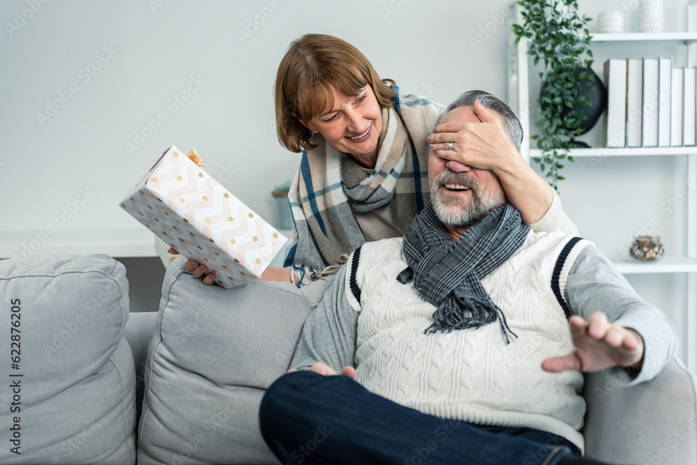 Caucasian senior elderly woman surprise her husband with birthday gift. 