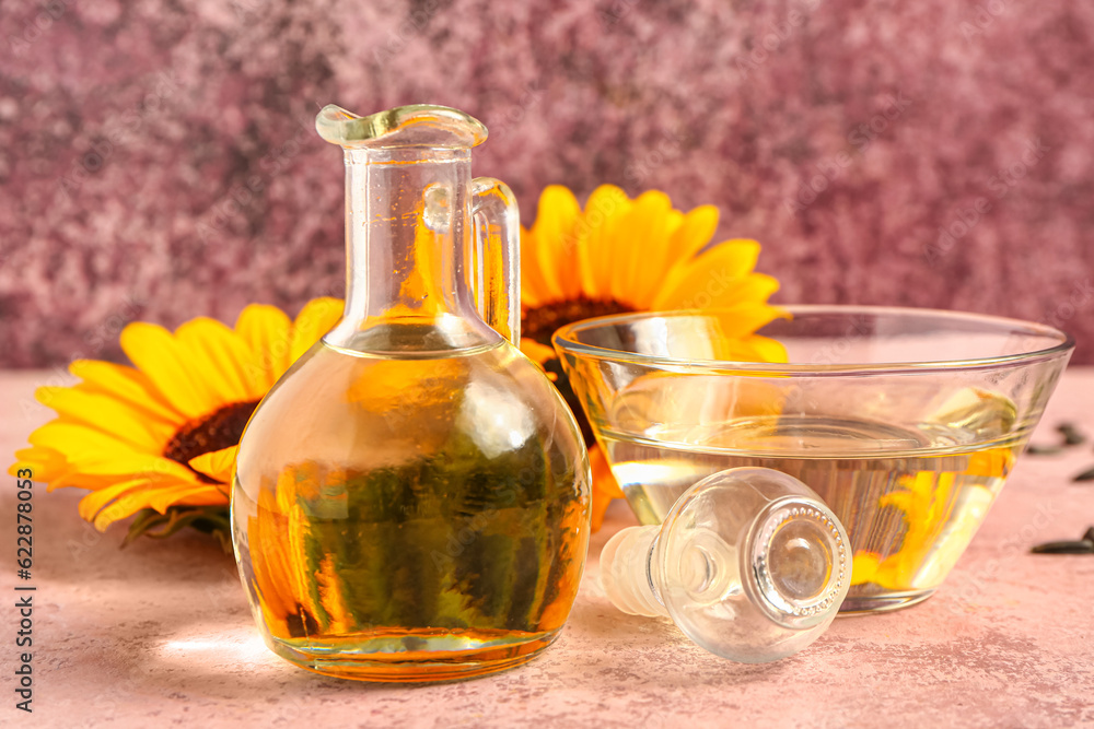 Bowl and decanter of sunflower oil on pink background