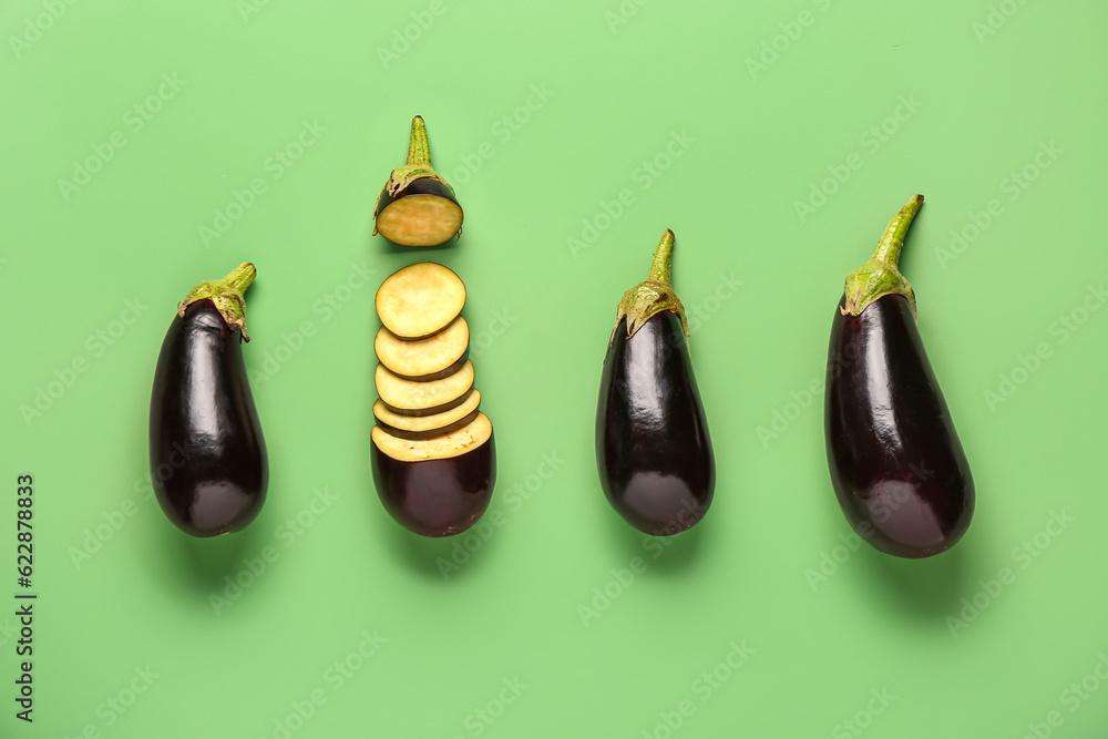 Fresh eggplants on green background