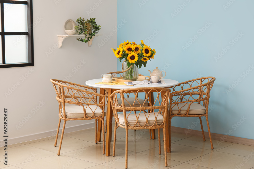 Vase with beautiful sunflowers on dining table