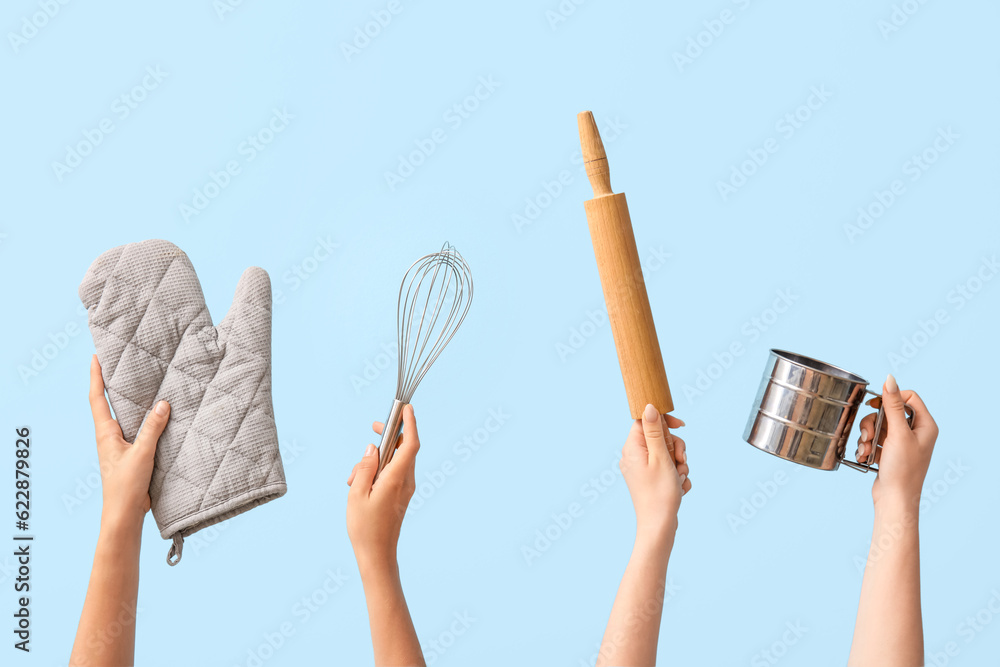 Female hands with baking utensils on blue background