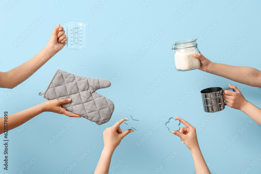 Female hands with baking utensils on blue background