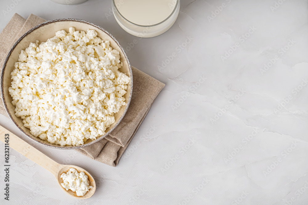 Bowl with tasty cottage cheese on light background