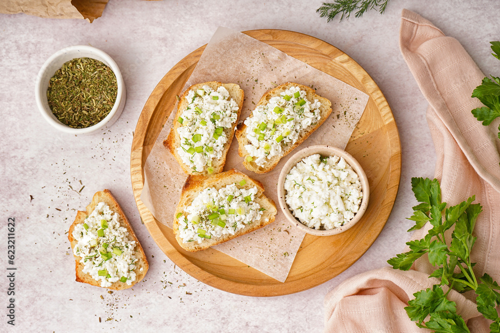 Sandwiches with tasty cottage cheese and green onion on table