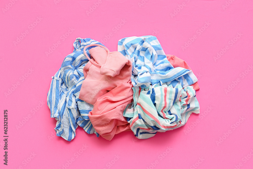 Pile of dirty clothes on pink background