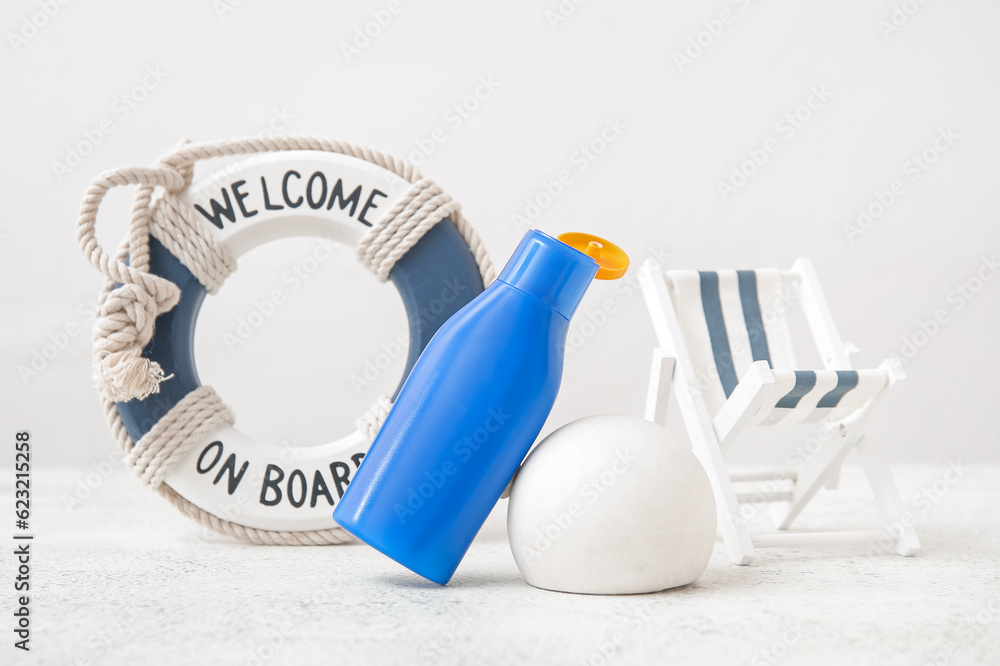 Composition with bottle of sunscreen cream, plaster podium and decor on light background