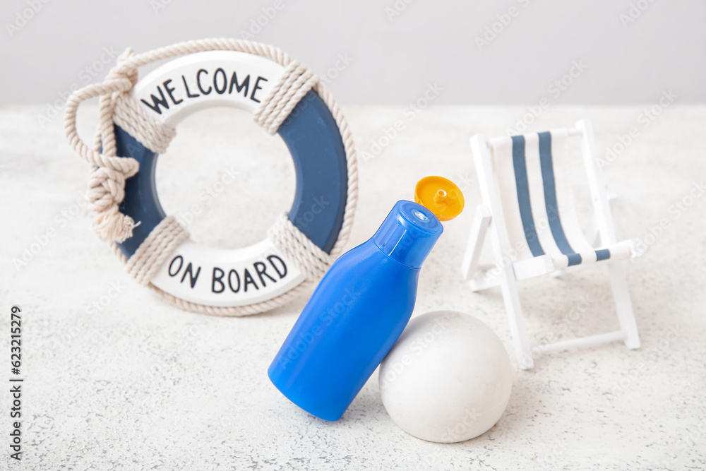 Composition with bottle of sunscreen cream, plaster podium and decor on light background