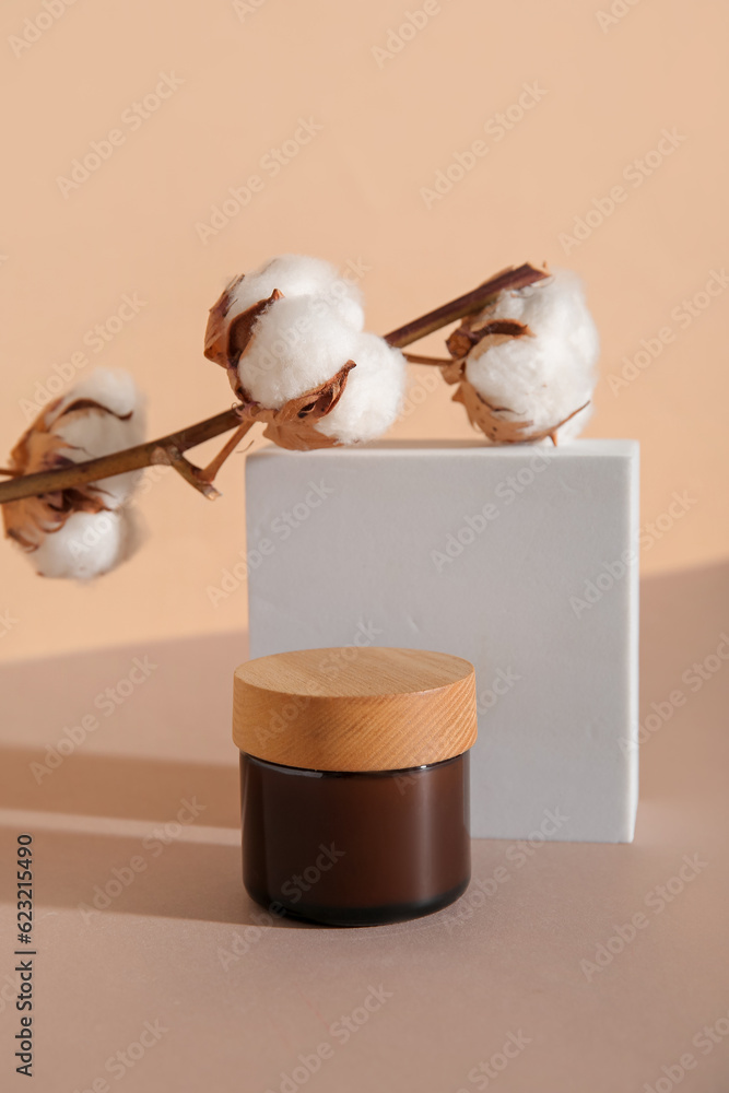 Jar of cosmetic product, plaster podium and cotton branch on color background