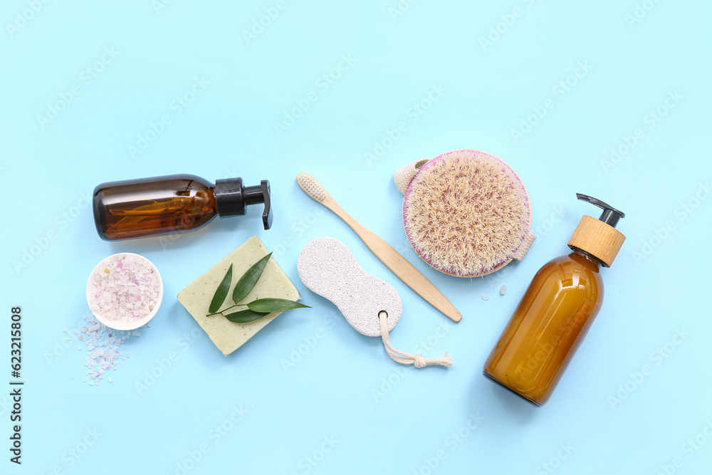 Composition with bath accessories and bottles of cosmetic products on color background