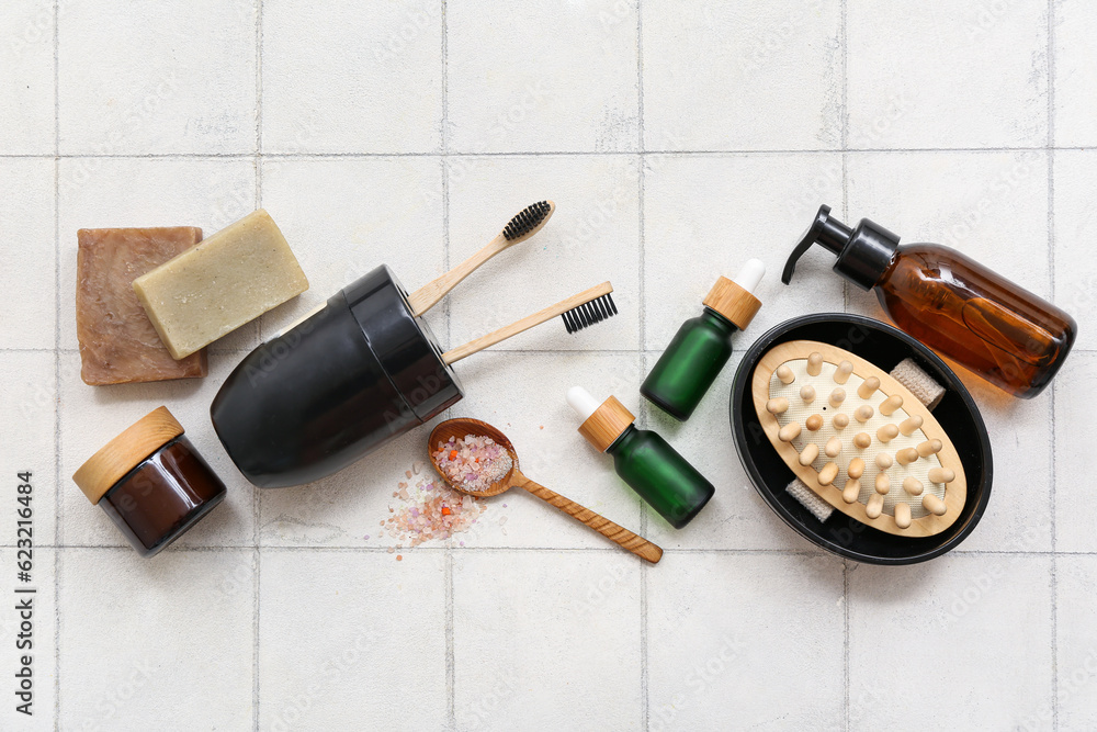 Composition with different bath accessories and cosmetic products on light tile background