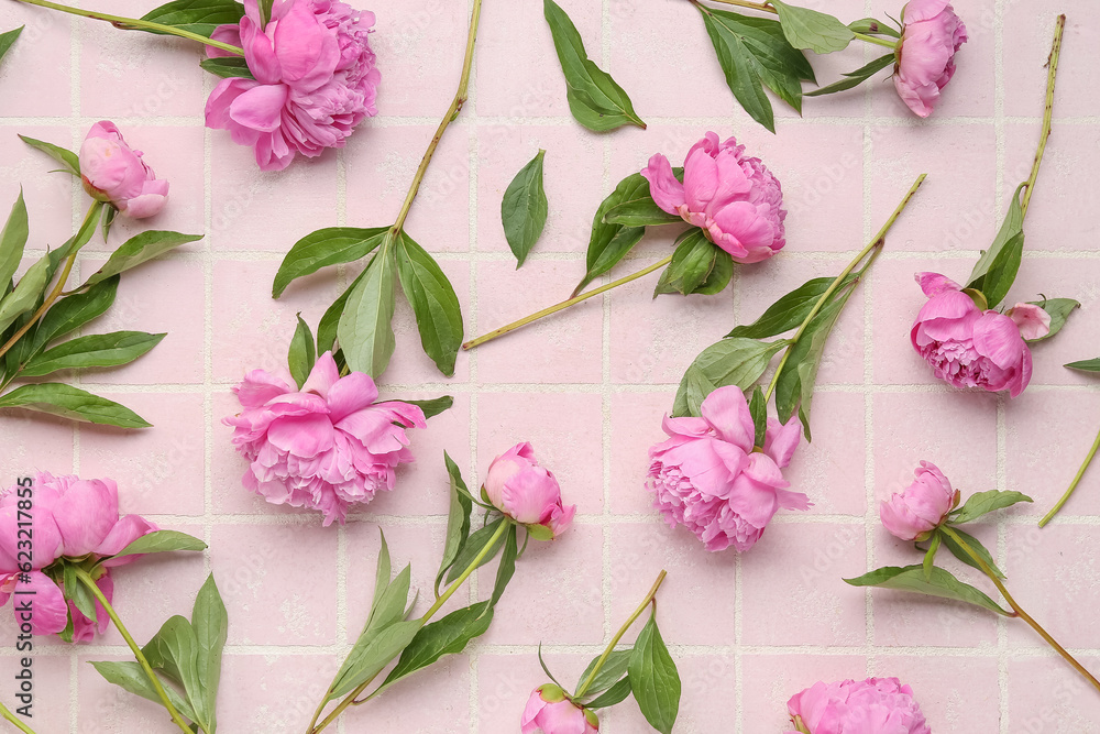 Composition with beautiful peony flowers on color tile background