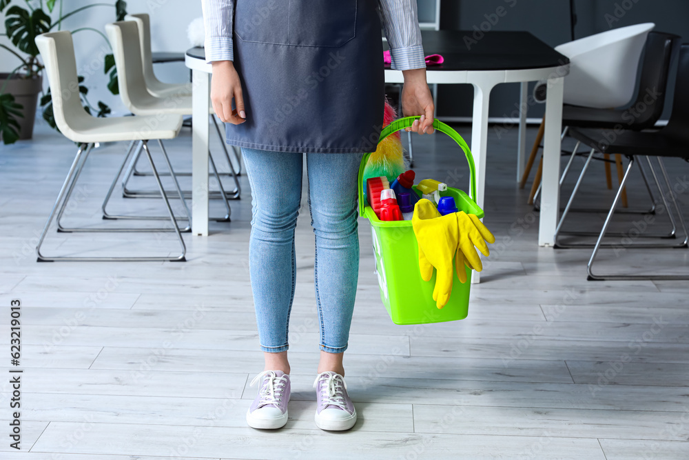 Female janitor with cleaning supplies in office