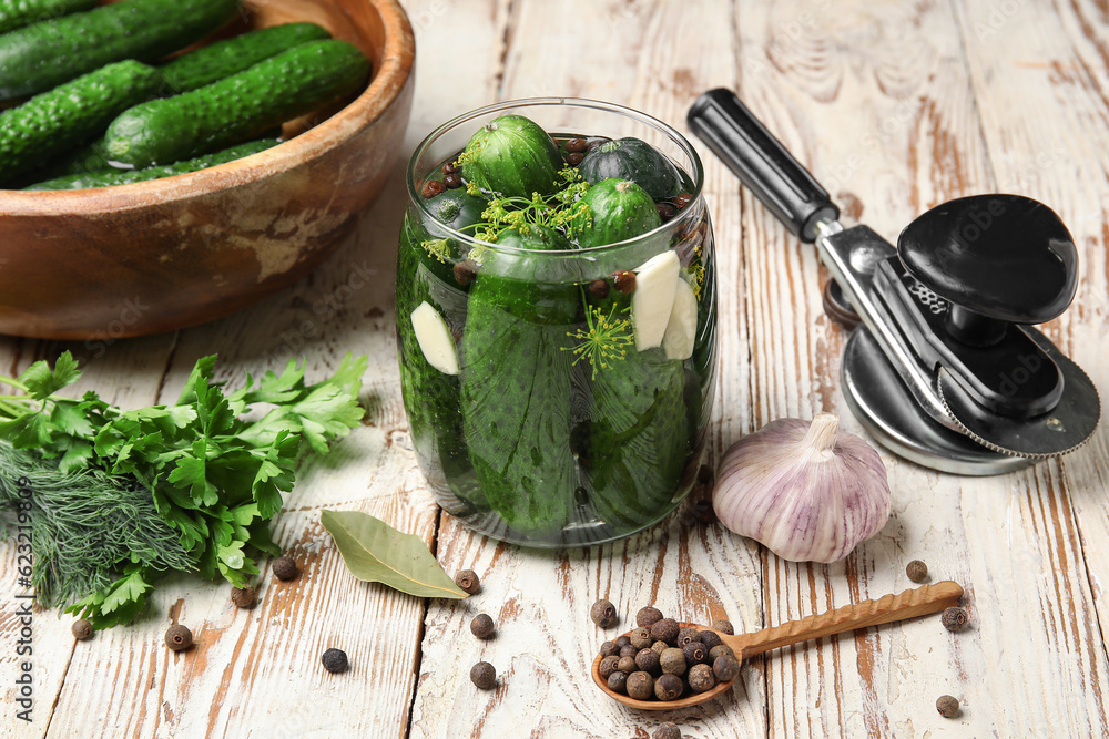 Jar with fresh cucumbers for preservation on light wooden background