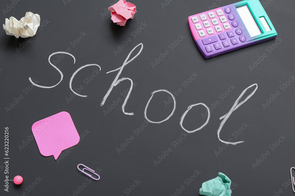 Different stationery with word SCHOOL on black chalkboard