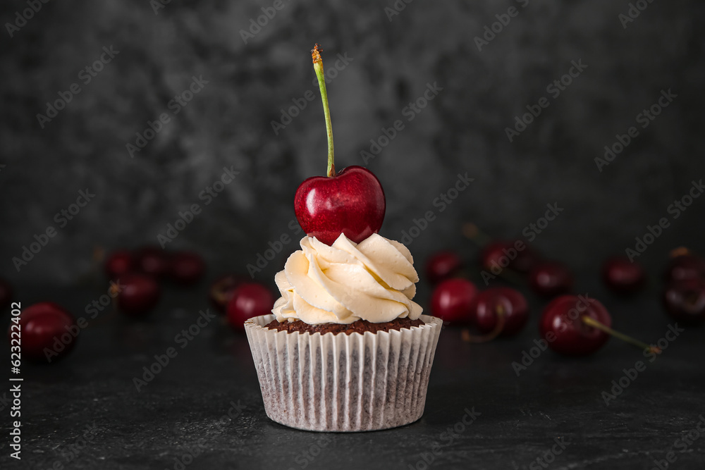 Tasty cherry cupcake on black background