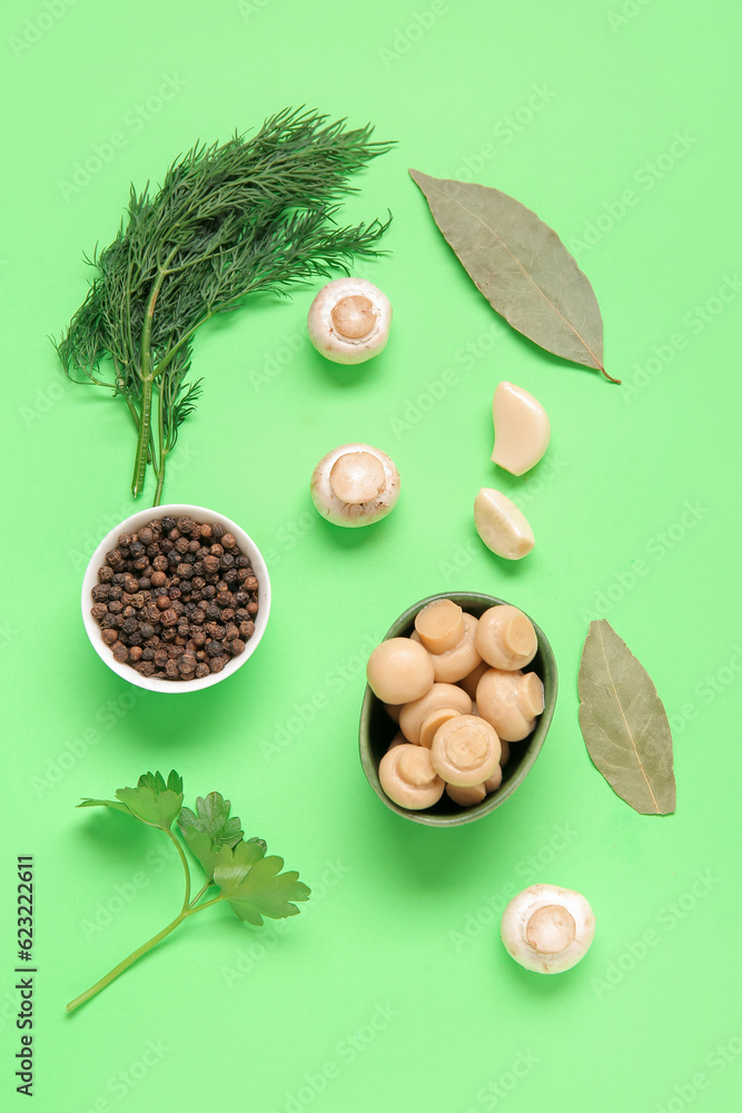 Bowl with canned mushrooms and ingredients for preservation on green background