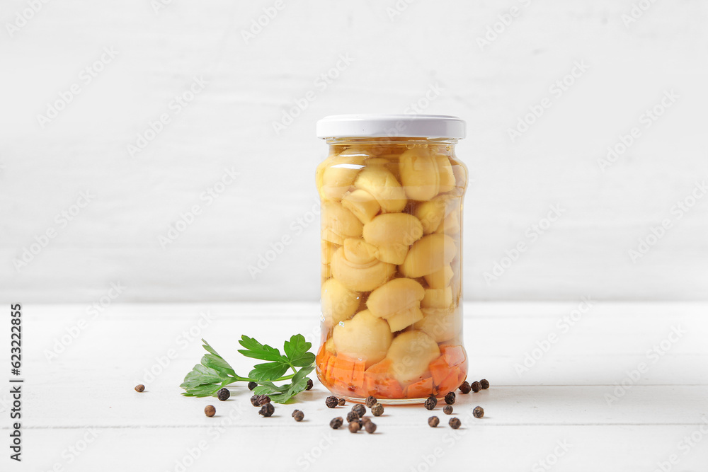 Jar with canned mushrooms on table