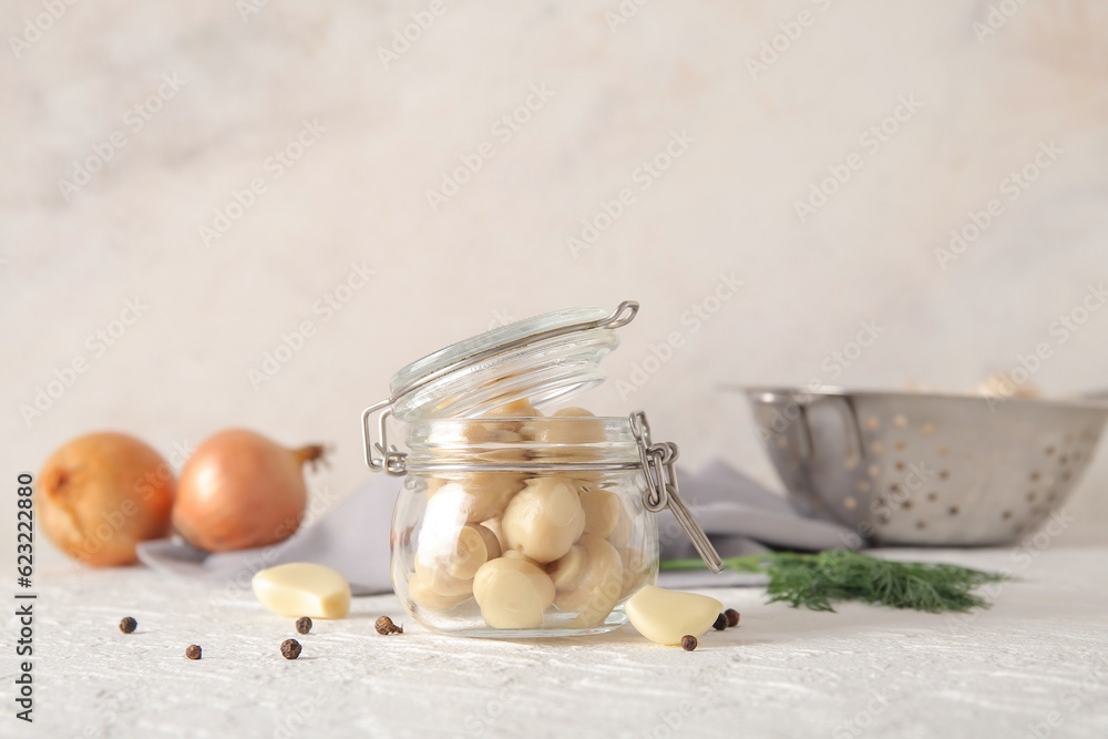 Jar with canned mushrooms on light background