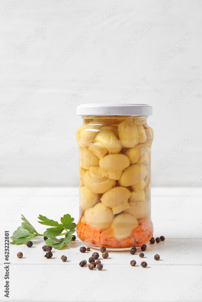 Jar with canned mushrooms on table