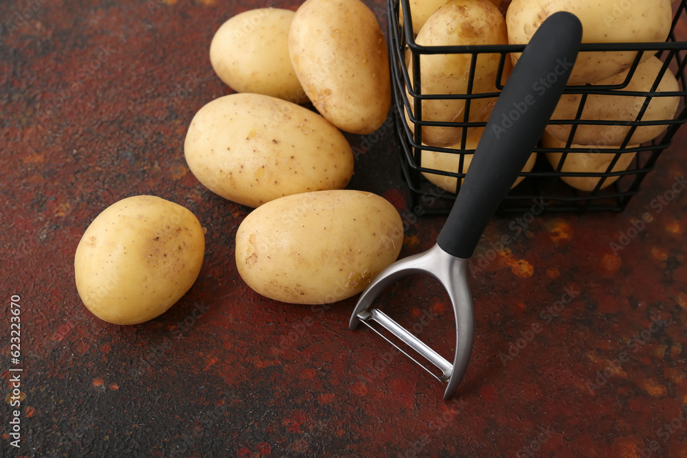 Basket with raw potatoes on dark background