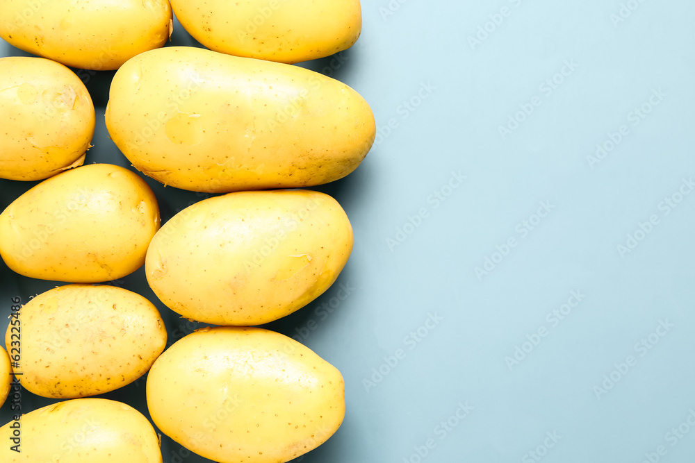 Raw potatoes on blue background