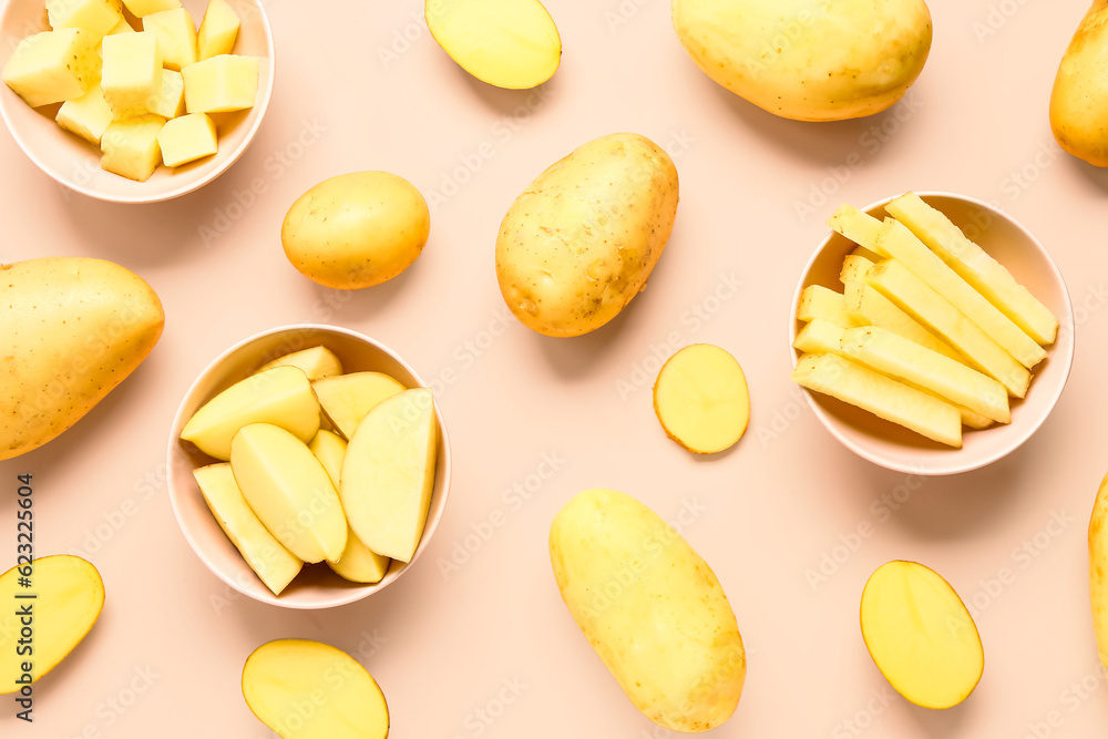 Bowls with cut and whole potatoes on pink background