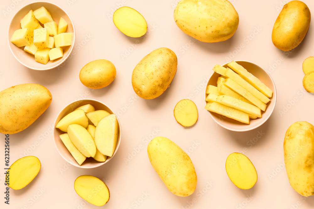 Bowls with cut and whole potatoes on pink background