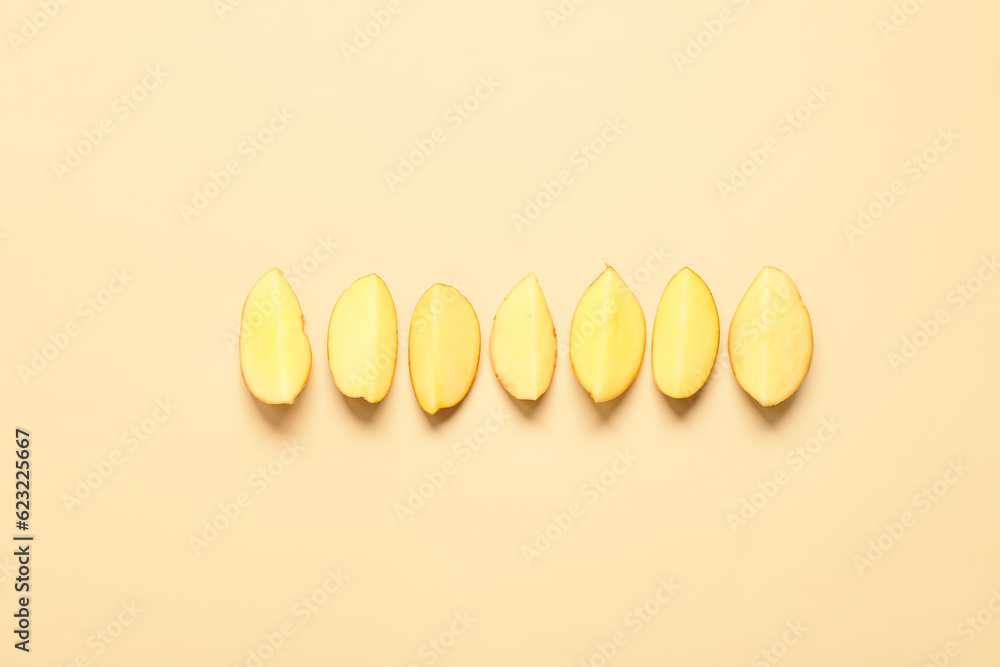 Pieces of raw potatoes on yellow background