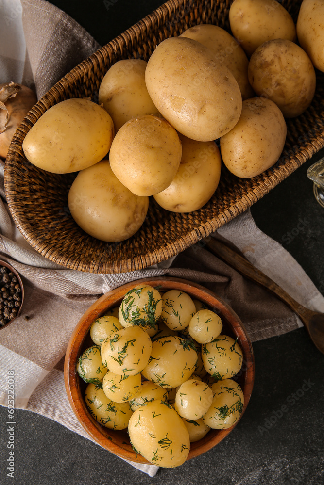 Boiled and raw baby potatoes on black background