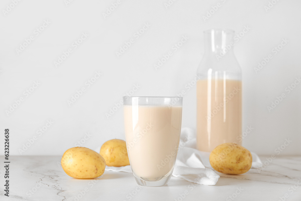 Glass of tasty potato milk on table