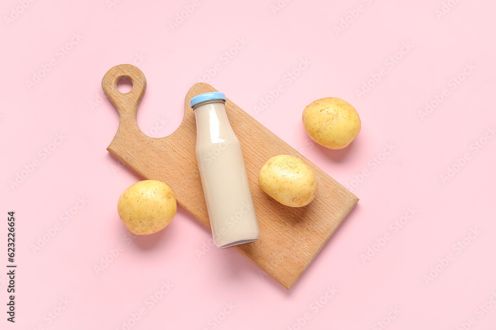 Bottle of tasty potato milk on pink background