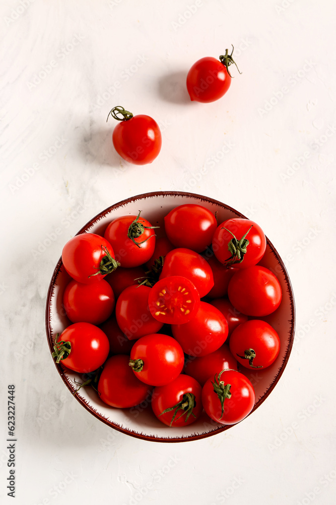 Bowl with fresh cherry tomatoes on white background