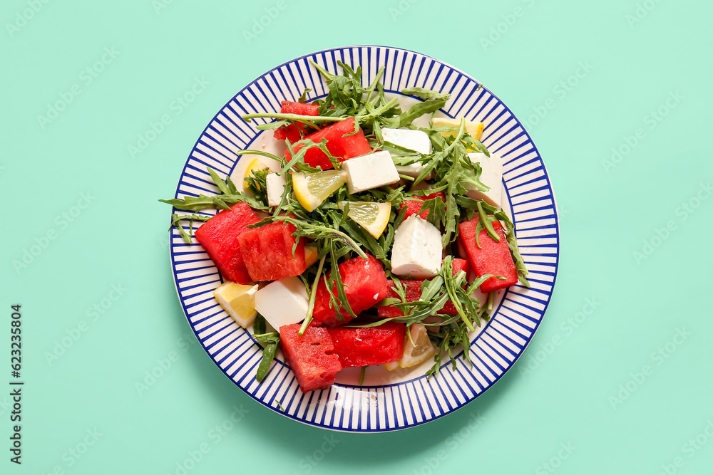 Plates of tasty watermelon salad on turquoise background