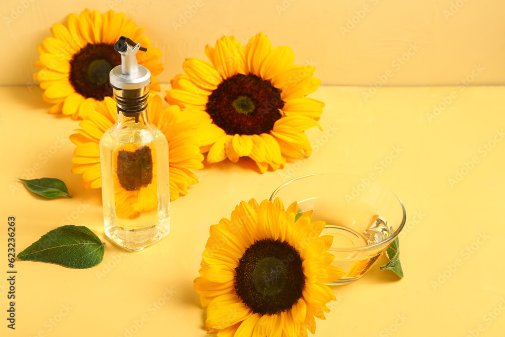 Sunflowers, bottle and bowl of oil on yellow background