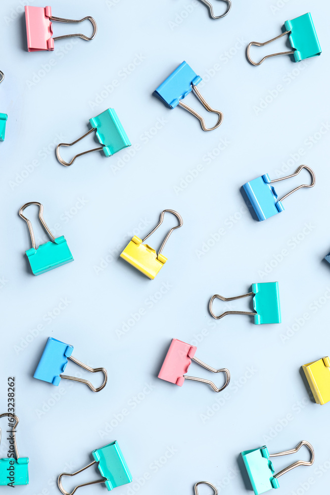 Colorful binder clips on light blue background