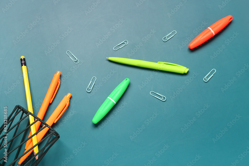 Holder with stationery and paper clips on blue background