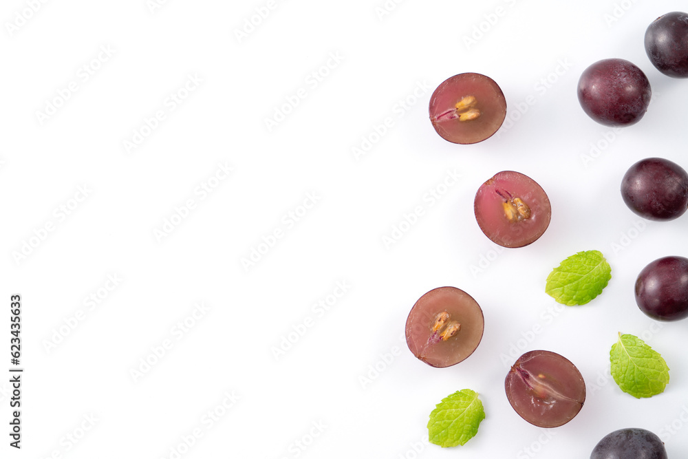 Delicious bunch of grapes fruit spilled over white table background.